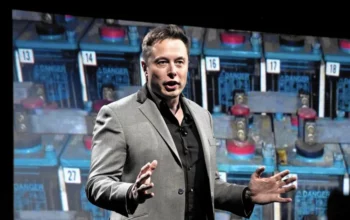 Elon musk giving a speech in front of batteries
