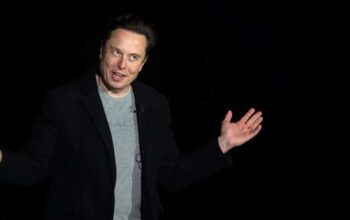 elon musk throws his hands in the air