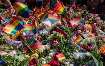 Flowers and rainbow flags are left along the street near a restaurant where two people were injured and at least 10 were injured when a man opened fire early Saturday morning near a popular gay club in the city's downton on June 25, 2022 in Oslo, Norway.