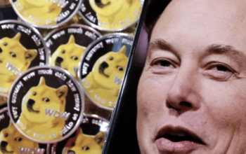 A photo of Elon Musk is displayed on a smartphone placed on representations of cryptocurrency Dogecoin