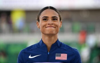 Gold medallist and world record holder USA's Sydney Mclaughlin poses on the podium